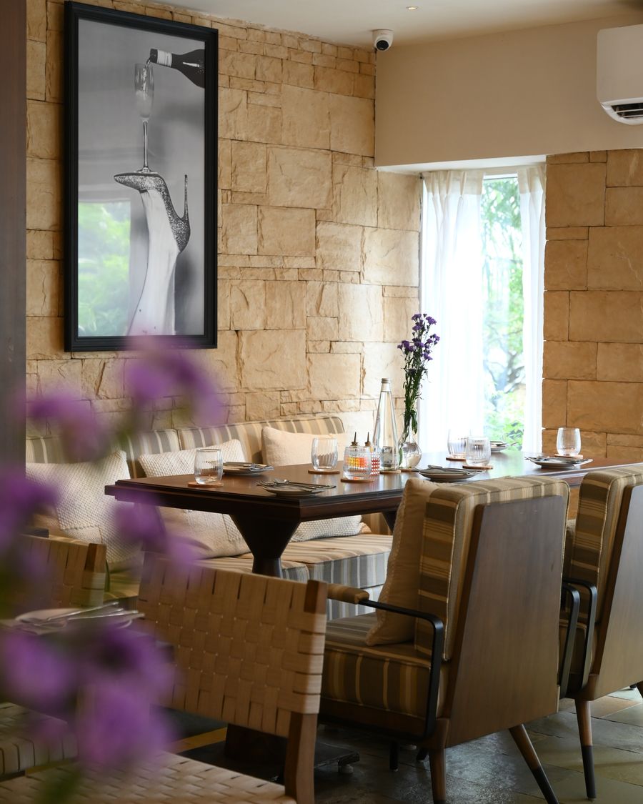 The dining room, stone walls and seating beneath a curtained window