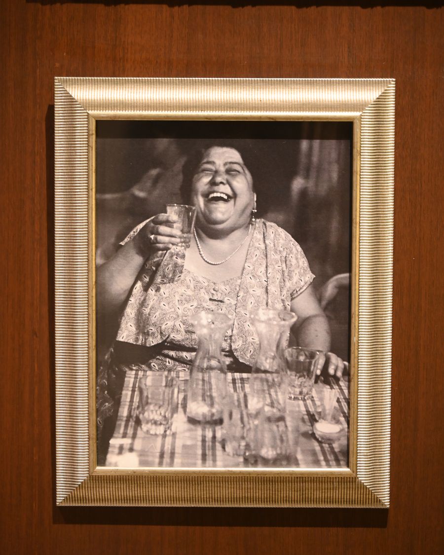 A gilt-framed portrait of a woman laughing