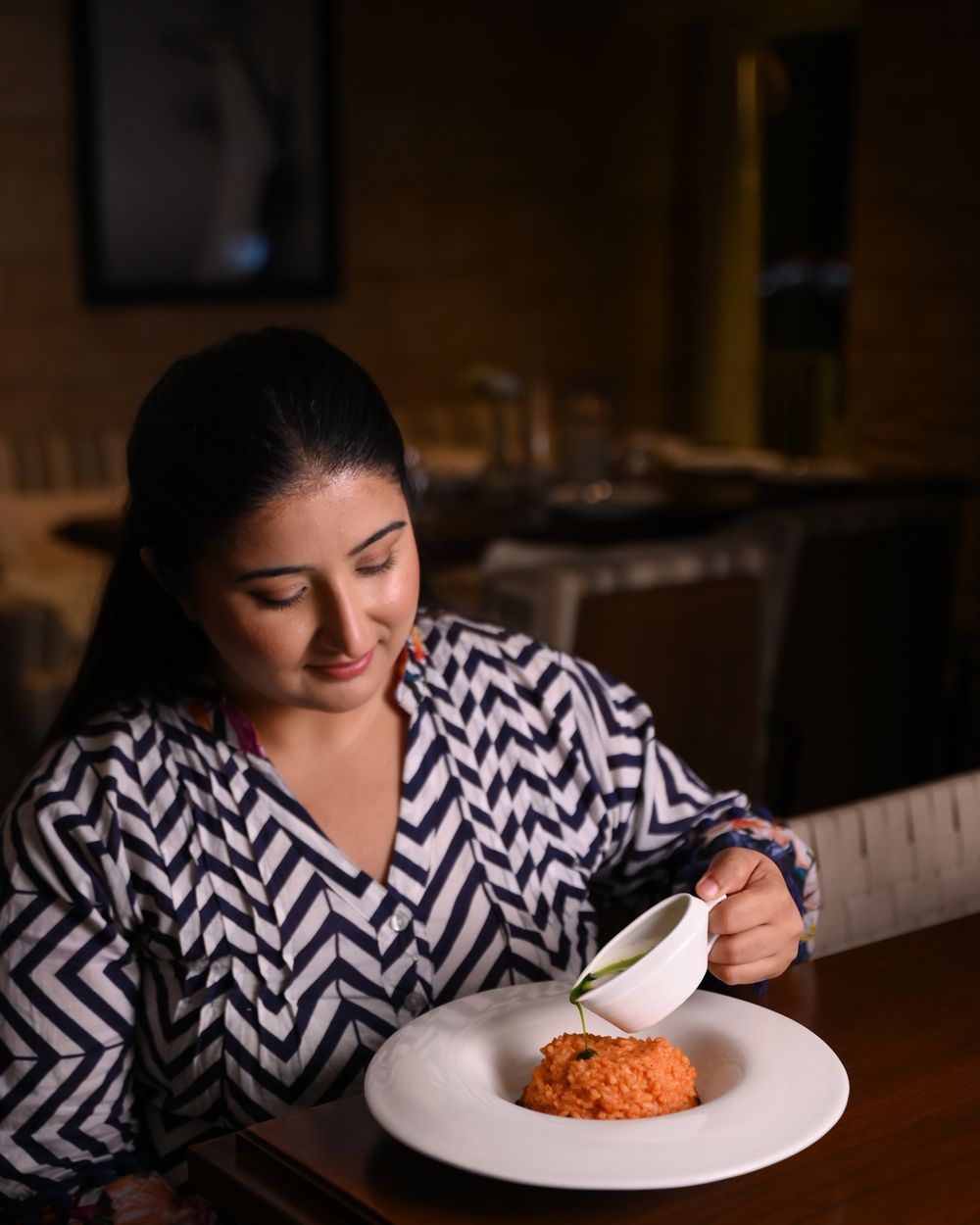 Chef Kamalika Anand finishing a plate at the pass