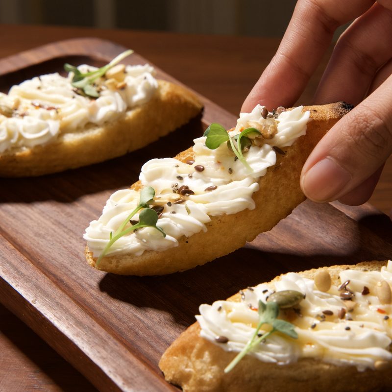 Bruschetta topped with whipped ricotta, hot honey and micro herbs
