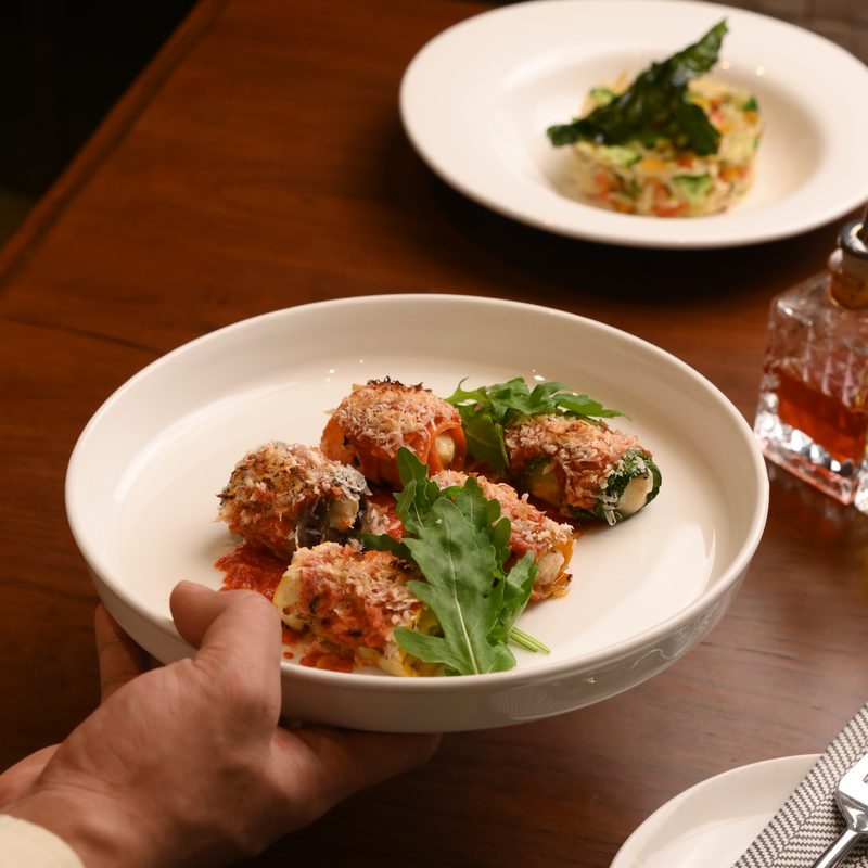 Vegetable involtini in tomato sauce, finished with rocket